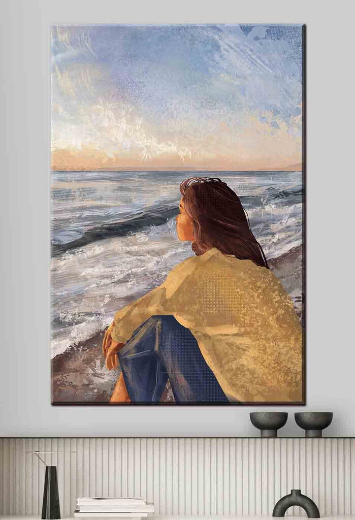 A woman sitting on a beach looking out to the ocean A woman sitting on a beach looking out to the ocean