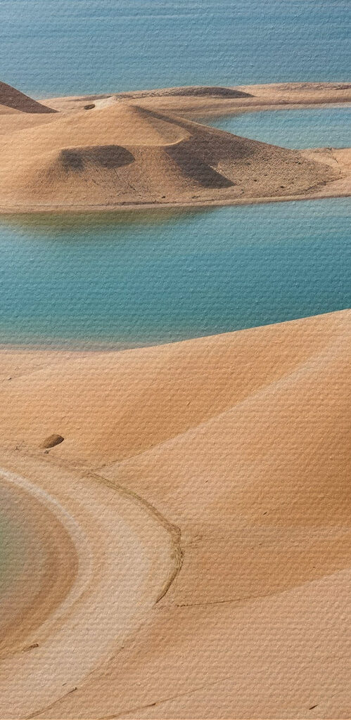 Desert with water and mountains in the background