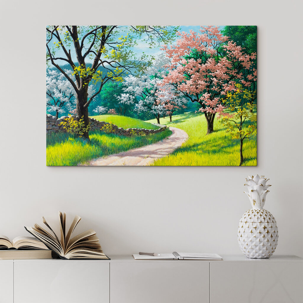 A dirt road through a grassy field with trees and a stone wall