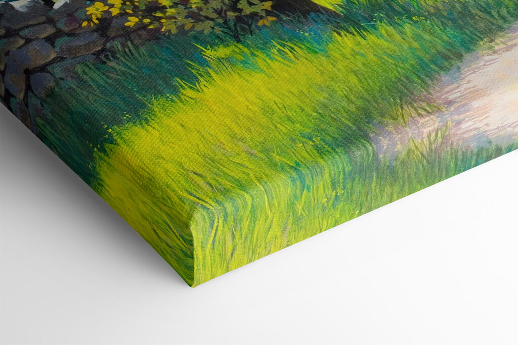 A dirt road through a grassy field with trees and a stone wall