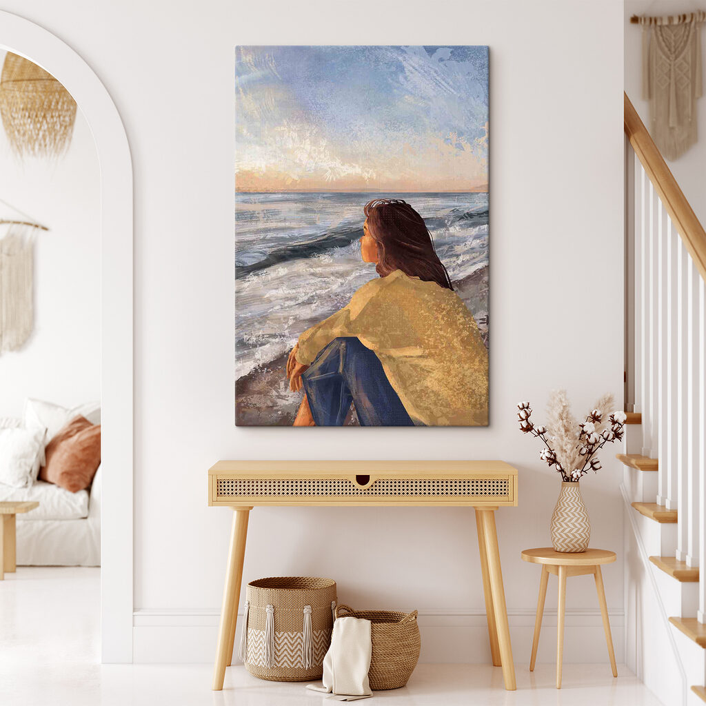 A woman sitting on a beach looking out to the ocean A woman sitting on a beach looking out to the ocean