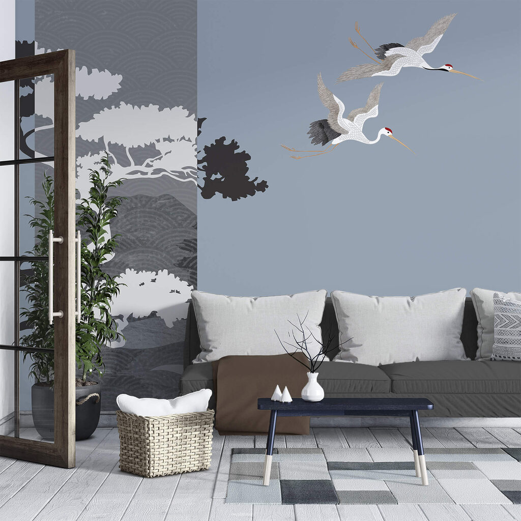 Pár žeriavov letiacich vedľa stromu